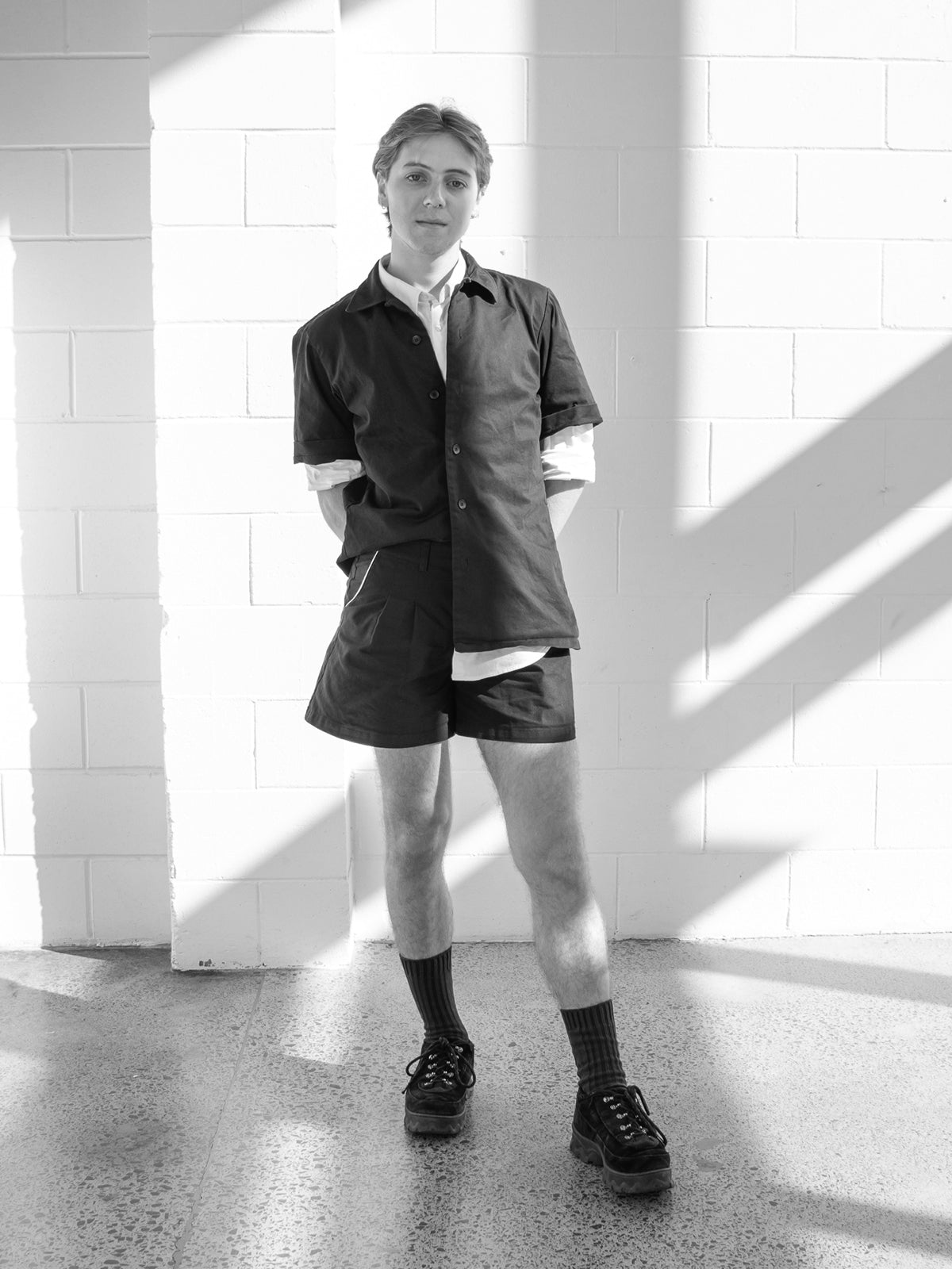 JH Intern Quinn photographed standing in-front of a sunlit wall in our Workroom.