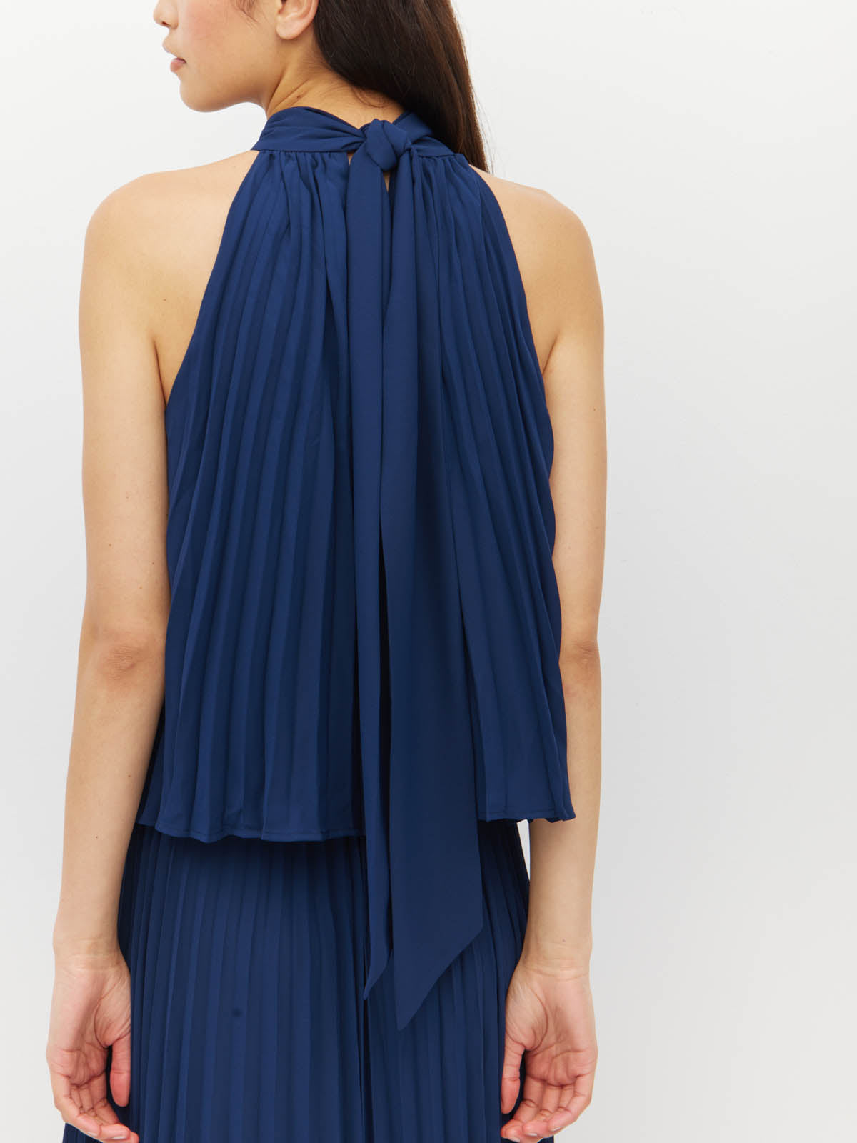 Juliette Hogan Amira Dress (Matte Pleat) Navy - pleated event dress with high tie neckline, elasticated waist, and ankle-length hem.
